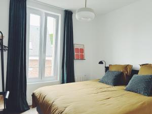 a bedroom with a bed and a window at Suite Jaurès in Rethel