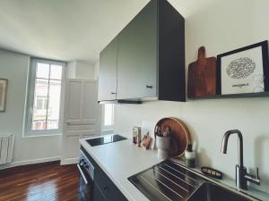 a kitchen with a sink and a counter top at Suite Jaurès in Rethel