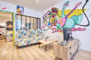 a living room with a couch and a painting on the wall at Les apparts du TRECH in Tulle