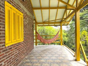 a patio with yellow shutters and a hammock at Pousada da Chacara in Nova Petrópolis