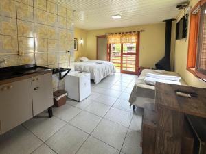 a large room with two beds and a kitchen at Pousada da Chacara in Nova Petrópolis +285 photos