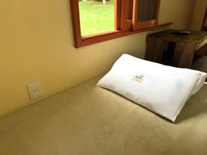 a white pillow sitting in a room with a window at Pousada da Chacara in Nova Petrópolis