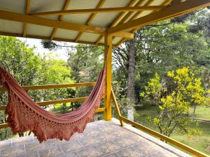 a hammock on the porch of a house at Pousada da Chacara in Nova Petrópolis