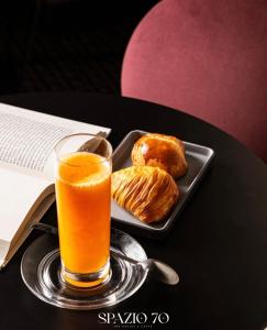 a glass of orange juice next to a plate of food at Volta 70 in Naples
