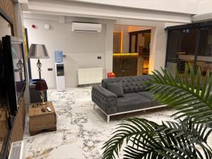 a living room with a couch and a tv at Airport Corner Hotel in Trabzon