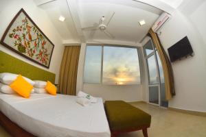 a bedroom with a bed and a large window at Ayurvedic Beach Resort in Negombo
