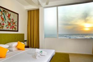 a bedroom with a bed with a view of the ocean at Ayurvedic Beach Resort in Negombo