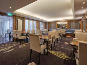 a dining room with tables and chairs and windows at Classik Hotel Hackescher Markt - Self Check In in Berlin