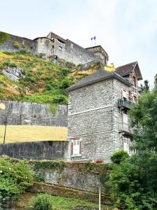 an old building on a hill with a castle at La Rose du Château in Lourdes