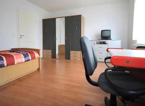 a bedroom with a desk and a bed and a chair at Privatzimmer Ahlten in Lehrte