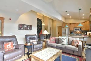 a living room with leather furniture and a kitchen at Mt. Victoria Lodge Penthouse Condo: Downtown, Hot Tub in Frisco