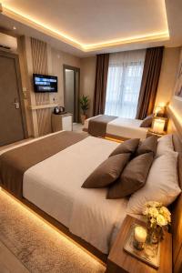 a hotel room with two beds and a television at Airport Corner Hotel in Trabzon