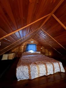 a bed in a wooden attic with a window at בקתת העץ של מירה ואמיר in Beit Hillel