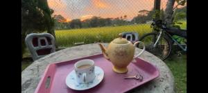 a tea pot and a cup of coffee on a table at Hansika Guest Inn in Buttala