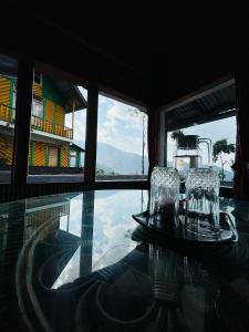 a glass table with two chairs on top of a pool at Red Panda Ecohut in Lava