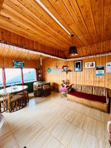 a room with a wooden ceiling and tables and chairs at Red Panda Ecohut in Lava