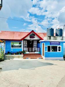 a blue house with a red roof at Red Panda Ecohut in Lava