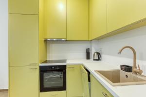 a kitchen with yellow cabinets and a sink at Green Oasis Bečići in Boreti
