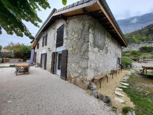 a stone building with benches in front of it at Naëlo Chartreuse in Biviers
