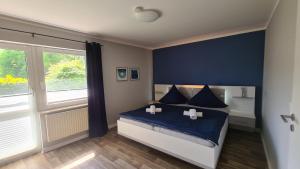 a bedroom with a bed with blue sheets and a window at 03 Blumenwiese - Hof Wiesengrund in Parchtitz +33 photos
