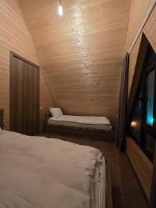a small room with two beds in a wooden cabin at Chalet Gudauri in Gudauri