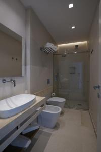 a bathroom with a toilet and a sink and a shower at Kalibia rooms and suites in Mazara del Vallo +41 photos