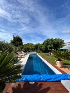 a swimming pool with chairs and a blue sky at La Note Bleue - Chambres d'hôtes in Échillais