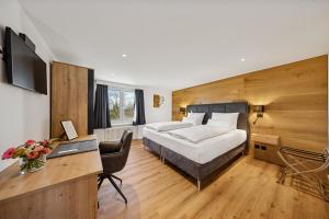 a hotel room with a bed and a desk at Suite4you Erlen l Privater Indoorpool ganzjährig beheizt & Sauna l 10min zum Bodensee, Parkplatz & WLAN in Erlen