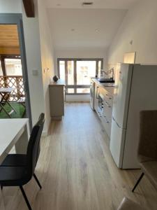 a kitchen with a refrigerator and a table with a chair at La Petite Ecole Chez Etche in Marciac