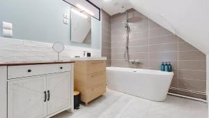 a bathroom with a white tub and a sink and a bath tub at Escapade à Blainville-Crevon in Blainville-Crevon +5 photos