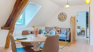 a dining room with a table and a couch at Escapade à Blainville-Crevon in Blainville-Crevon