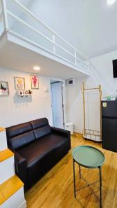a living room with a black leather couch and a table at บลูคริสตัลรีสอร์ทแหลมสิงห์ in Laem Sing