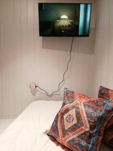 a bedroom with a bed with a tv on the wall at Sanur Backpacker Room Bali in Sanur