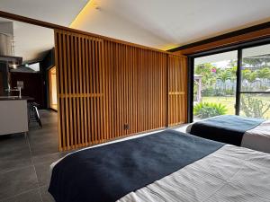 a bedroom with two beds and a large window at Ryukyu Garden in Nanjo +56 photos