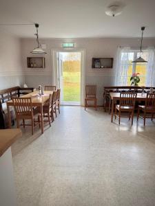 a dining room with wooden tables and chairs at Södra Ljunga Vandrarhem in Ljungby +56 photos