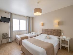 a hotel room with two beds and a television at Hotel Autre Mer in Noirmoutier-en-l'lle