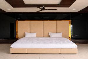 a large bed in a room with a ceiling at The Golden Wings Hotel in Dewās