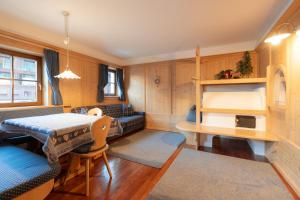 a room with a table and a bed and a desk at Apartments Mauriz in Selva di Val Gardena