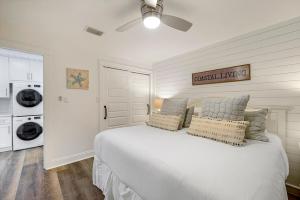 a bedroom with a white bed with a ceiling fan at Dune Villas 2A - Gulf Front Vacation Condominium with Shared Pool in Santa Rosa Beach +12 photos