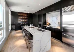 a kitchen with a large white island with bar stools at SE Furnished Apartment in Atlanta