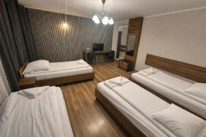 a hotel room with two beds and a desk at Hotel Bukowiec in Legionowo +33 photos