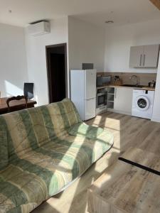 a living room with a couch and a kitchen at La Petite Ecole Chez Etche in Marciac +29 photos
