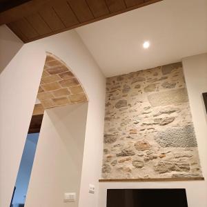 a stone wall in a room with a painting on the wall at Can Freixa in Sant Pere de Torelló