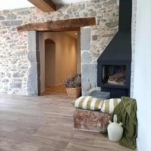 a living room with a fireplace and a stone wall at Can Freixa in Sant Pere de Torelló