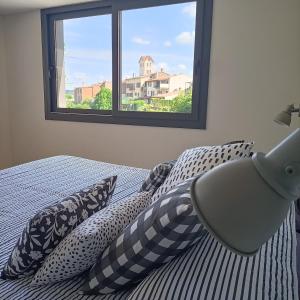 a bedroom with a bed with pillows and a window at Can Freixa in Sant Pere de Torelló
