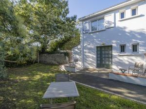 a white house with a picnic table in the yard at Hotel Autre Mer in Noirmoutier-en-l'lle