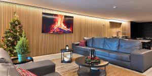 a living room with a blue couch and a christmas tree at Hotel Catanies in Pas de la Casa