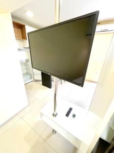 a flat screen tv on a white stand in a room at Studio Cafe duas camas de solteiro in Arapiraca