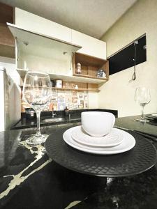 a table with a bowl and two wine glasses at Studio Cafe duas camas de solteiro in Arapiraca