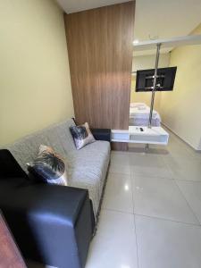 a living room with a couch and a mirror at Studio Cafe duas camas de solteiro in Arapiraca